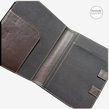 Load image into Gallery viewer, franklin-christoph.mommand Center Padfolio in black and brown leather with tan stitching. Features pen slot, document flap, and elastic closure.